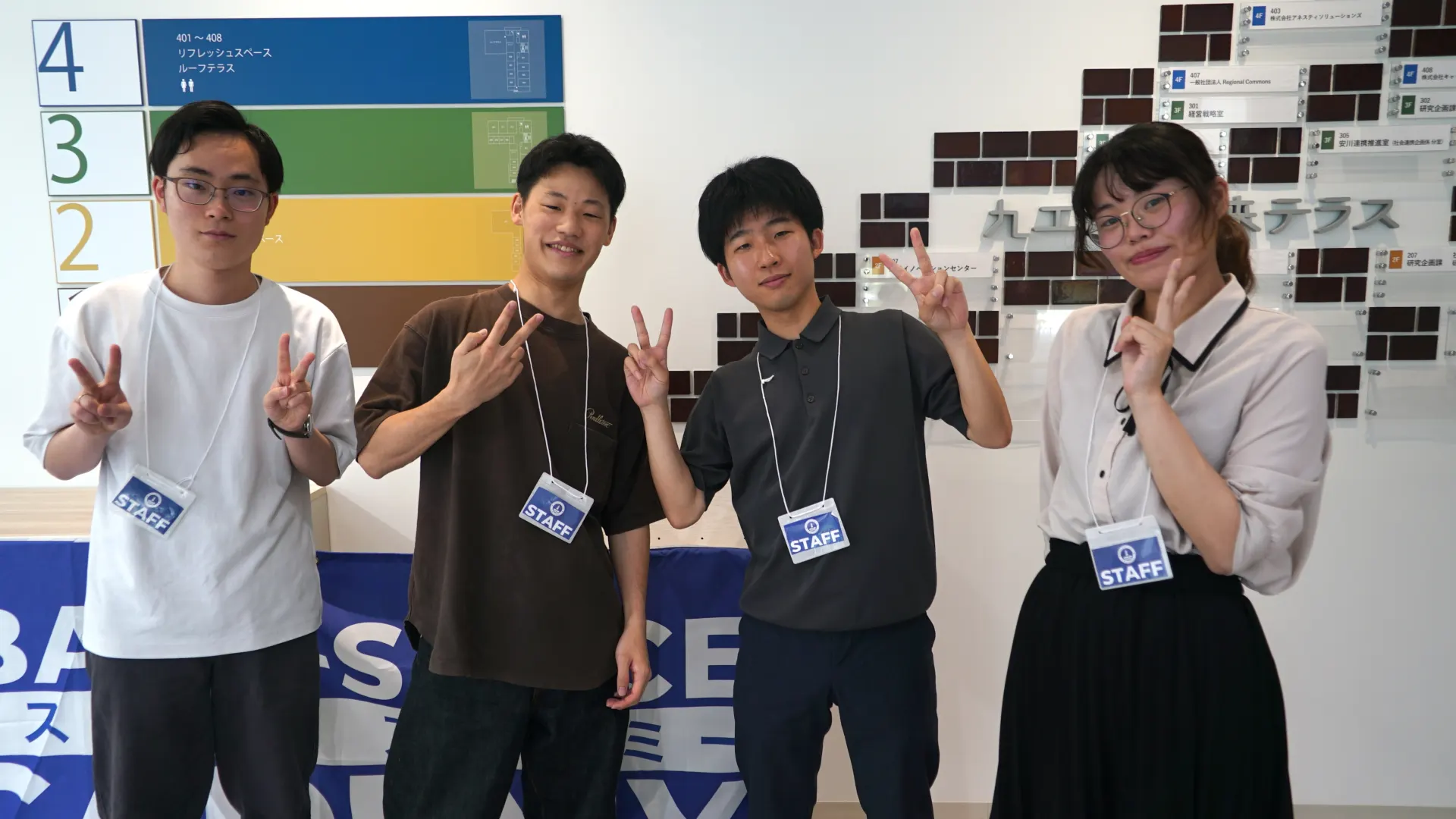 ピースサインで横並びになって写る、九工大の大学生・大学院生で構成されたTAメンバー4名