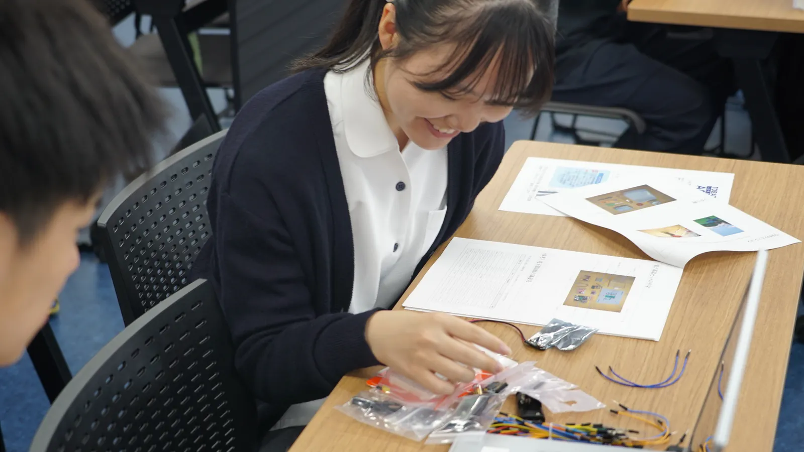 はじめて手にする電子部品の袋を、笑顔で開けるアカデミー生