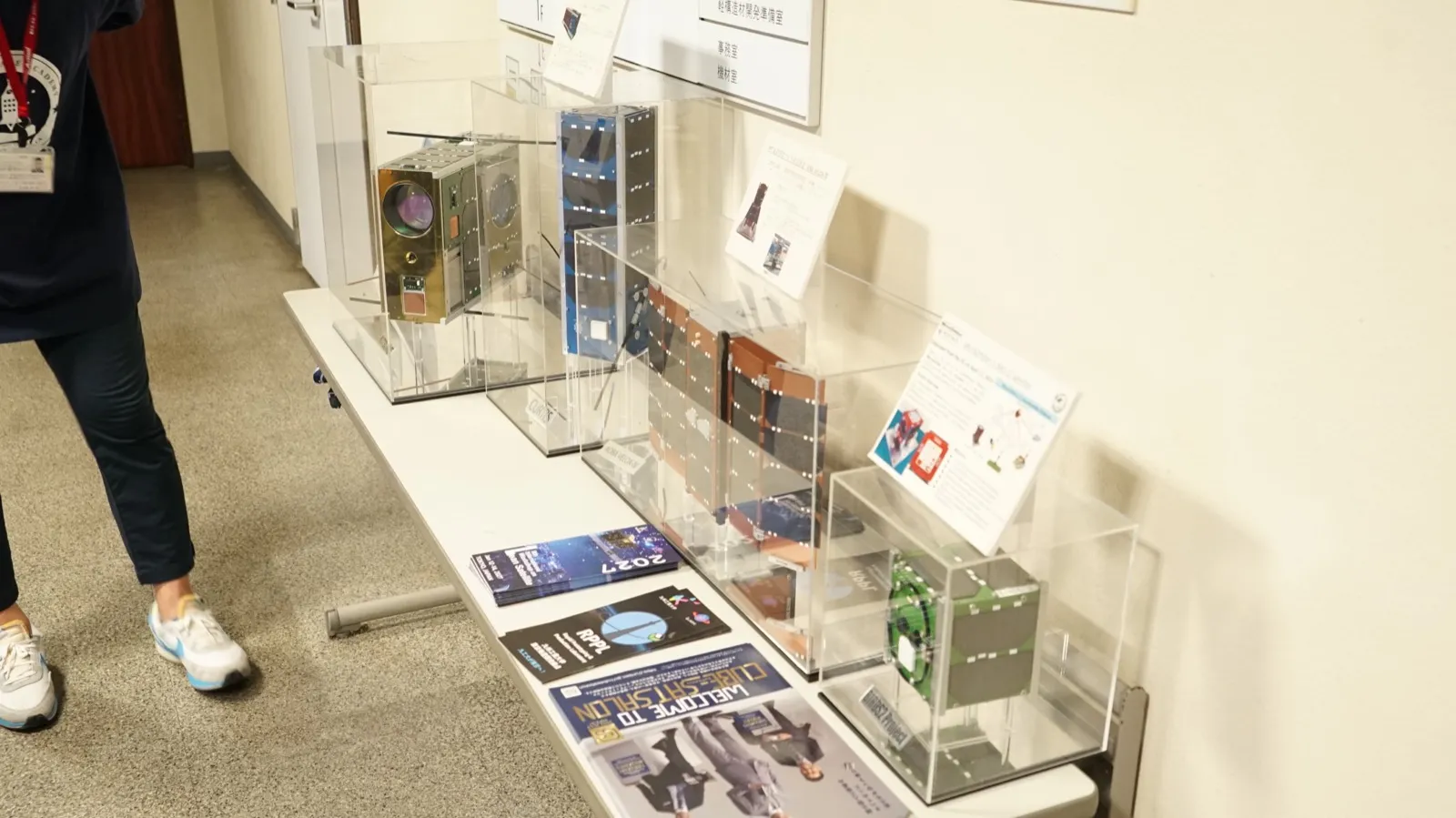 アクリルケースに入って展示された、九州工業大学の超小型衛星のモデル